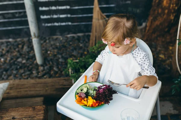 Little girl eating vegetable salad — Stock Image Little girl eating vegetable salad Royalty Free Stock Images