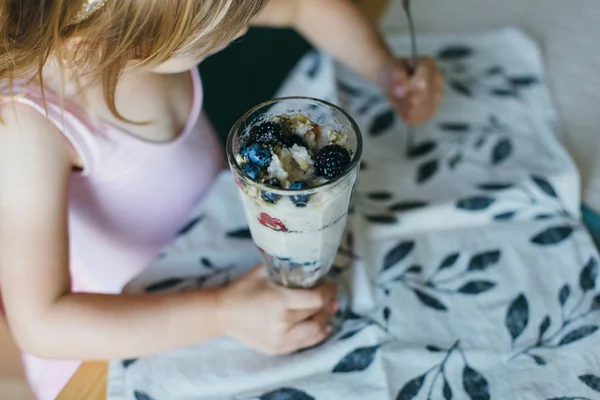 Little girl eating yogurt with berries — Stock Image Little girl eating yogurt with berries Stock Picture