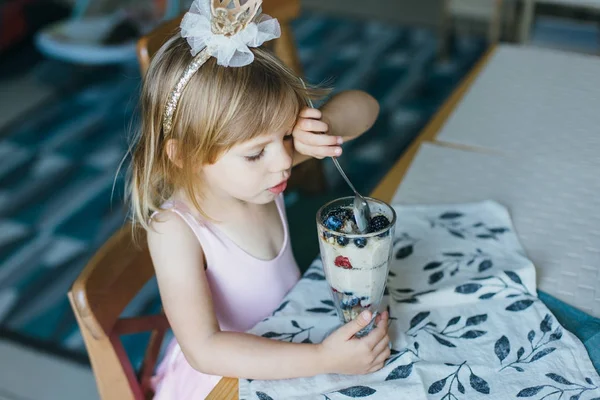 Little girl eating yogurt with berries — Stock Image Little girl eating yogurt with berries Royalty Free Stock Images