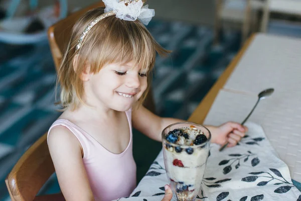 Little girl eating yogurt with berries — Stock Image Little girl eating yogurt with berries Stock Image