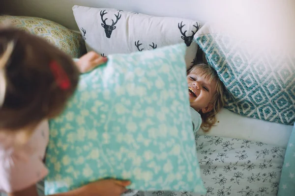 Irmãs pequenas se divertindo com travesseiros — Fotografia de Stock