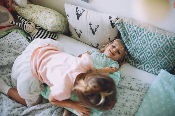 Little sisters having fun with pillows — Stock Photo, Image