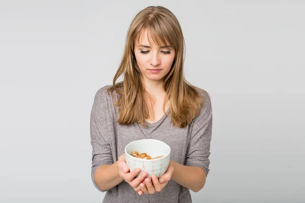 Woman holding bowl with almonds — Stock Photo, Image
