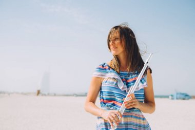 young beautiful woman holding the flute at beach clipart