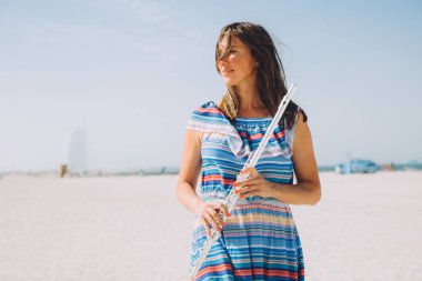 young beautiful woman holding the flute at beach clipart