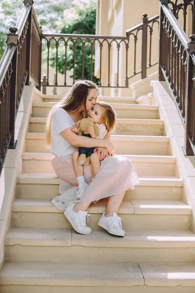 Feliz Bela Mãe Beijando Sua Adorável Filhinha Sentada Nas Escadas — Fotografia de Stock