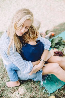 sevimli küçük oğlu rahatlatıcı sağlıklı gıda ile yaz piknikte olan kadın 