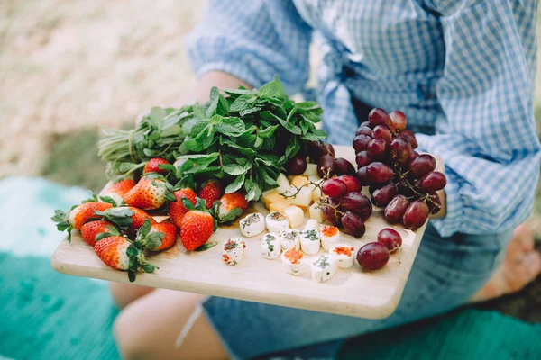 woman with healthy food relaxing at summer picnic