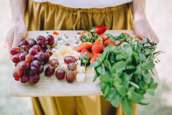 woman with healthy food relaxing at summer picnic