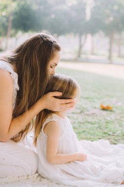 mutlu güzel genç anne onun sevimli küçük kızımız, Aile piknik yaz öpüşme portresi