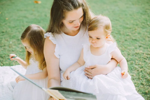 Две Симпатичные Маленькие Сестры Мать Читают Книгу Летнем Пикнике Парке — стоковое фото
