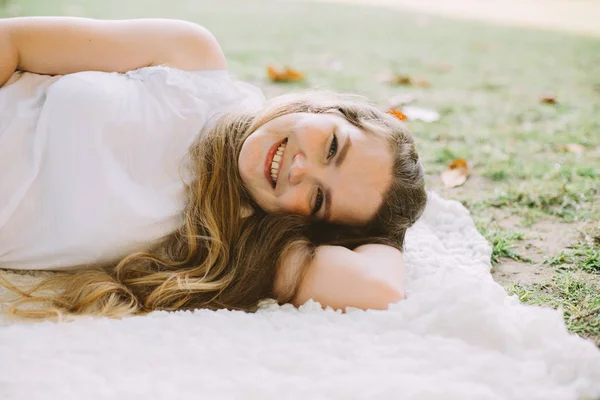 Красива Молода Жінка Посміхається Лежачи Білому Плащі Літньому Пікніку — стокове фото