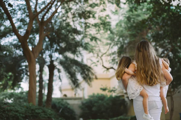 Portrait Beautiful Mother Carrying Her Adorable Little Daughters Park — Stock Photo, Image