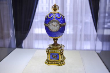 One of the famous egg made in the workshop of Faberge in the beginning of 20th century. This is a little clock installed into a gold and blue egg with a tiny cock on the top of that.