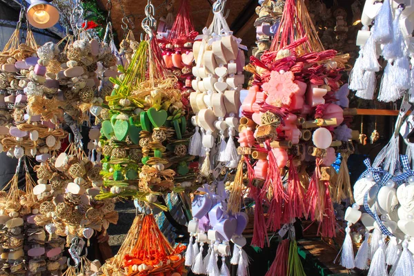 Bunches of hanging decorations made of soap and dry fruits on a Christmas market