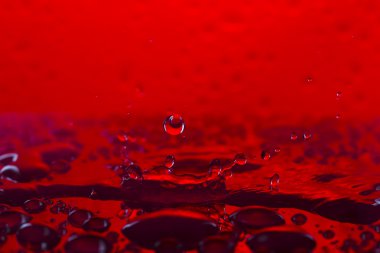 Damla, spreyler, renkli arka plan üzerinde su sıçramalarına