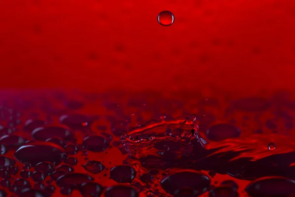 Drops, sprays, splashes of water on a colorful background — Stock Photo, Image