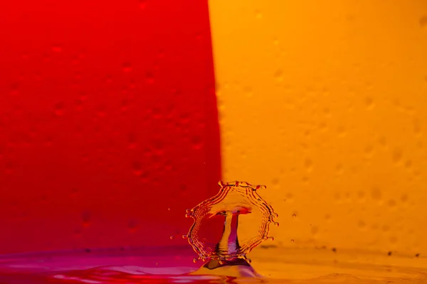 Drops, sprays, splashes of water on a colorful background — Stock Photo, Image