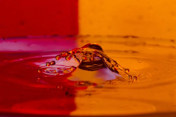 Drops, sprays, splashes of water on a colorful background — Stock Photo, Image