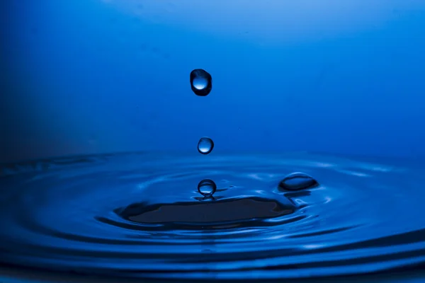 Drops, sprays, splashes of water on a colorful background — Stock Photo, Image