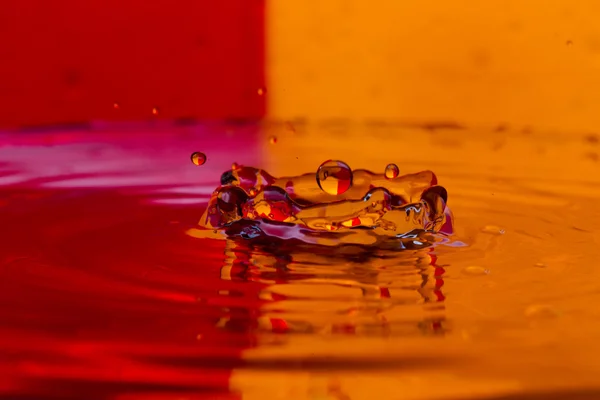 Tropfen, Sprays, Wasserspritzer auf buntem Hintergrund — Stockfoto