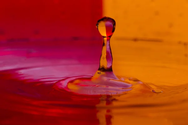 Tropfen, Sprays, Wasserspritzer auf buntem Hintergrund — Stockfoto