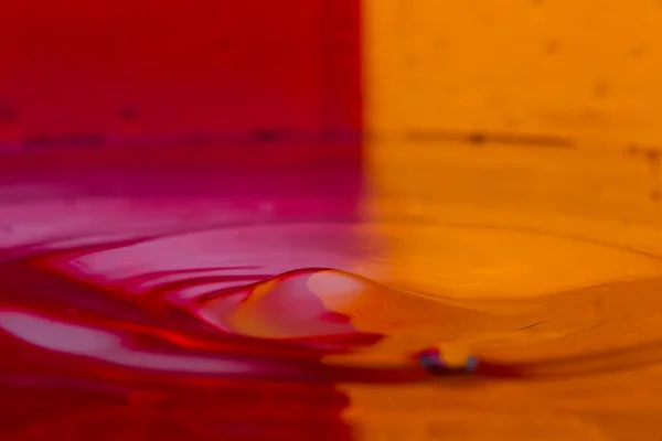Gocce, spray, spruzzi d'acqua su uno sfondo colorato — Foto Stock