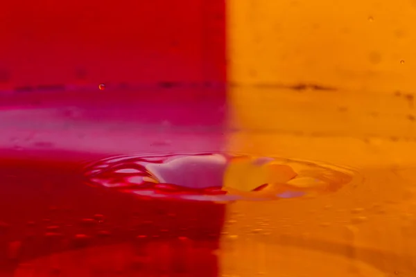 Gotas, aerosoles, salpicaduras de agua sobre un fondo colorido — Foto de Stock