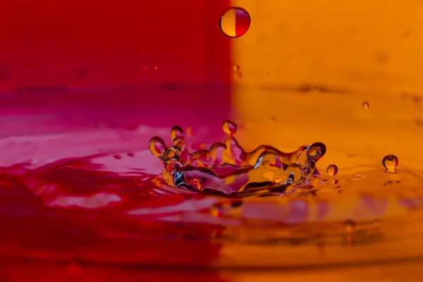 Gocce, spray, spruzzi d'acqua su uno sfondo colorato — Foto Stock