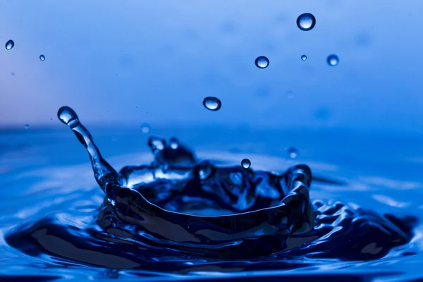 Tropfen, Sprays, Wasserspritzer auf buntem Hintergrund — Stockfoto