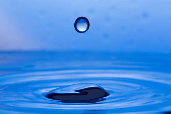 Gotas, aerosoles, salpicaduras de agua sobre un fondo colorido — Foto de Stock