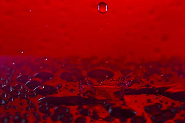 Drops, sprays, splashes of water on a colorful background — Stock Photo, Image