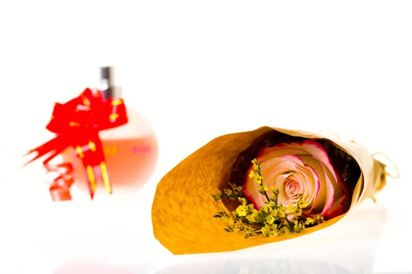 Buquê de flores em pergaminho e um presente em umas costas brancas — Fotografia de Stock