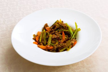 Tablo üzerinde plaka duran sebze ile kızarmış et