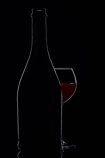 Copos de vinho com garrafa de vinho em um fundo preto, minimalismo , — Fotografia de Stock
