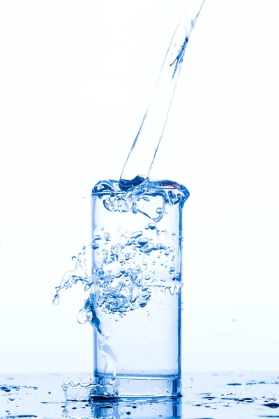 Bicchiere con acqua potabile versante — Foto Stock