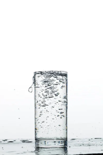 Glass with pouring drinking water — Stock Photo, Image