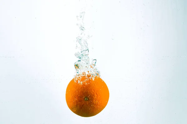 Orange in streams of water on a white background Stock Photo