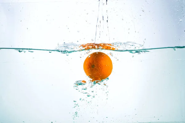 Orange in streams of water on a white background Stock Picture