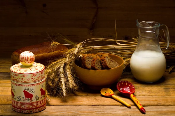 Glass jug with milk, mug with milk, a loaf of rye bread, ears — Stock Photo, Image