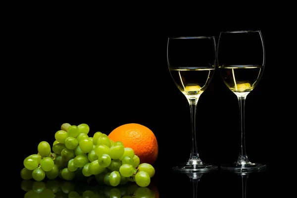 Okulary dla wina, winogron i pomarańczy na czarnym tle — Zdjęcie stockowe