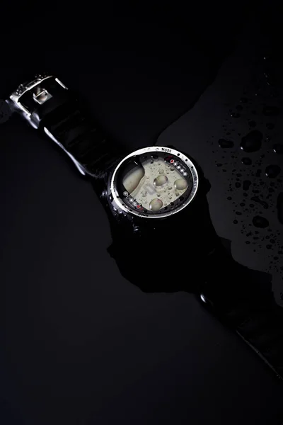 Komputer zegarek do nurkowania w strumieniach wody na czarnym tle — Zdjęcie stockowe