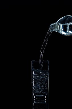 Su içine dökülen siyah bir arka plan üzerinde stüdyo ışık