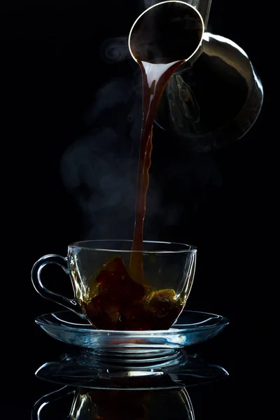 Café é derramado em uma xícara de vidro dos turcos, um backgr preto — Fotografia de Stock