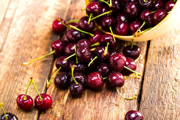 Berries of a sweet cherry in a wooden plate on a background of b — Stock Photo, Image