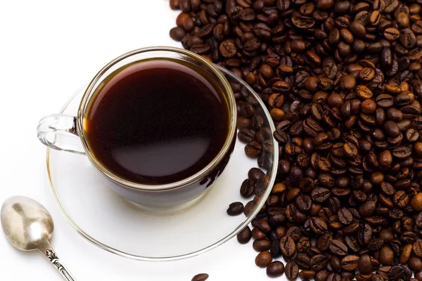 Чорна кава в скляній чашці і зерна кави на білій спині — стокове фото