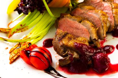 Fırında ördek sebze ve otlar stüdyo ışık beyaz bir tabakta yemek