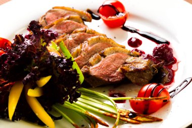 Fırında ördek sebze ve otlar stüdyo ışık beyaz bir tabakta yemek