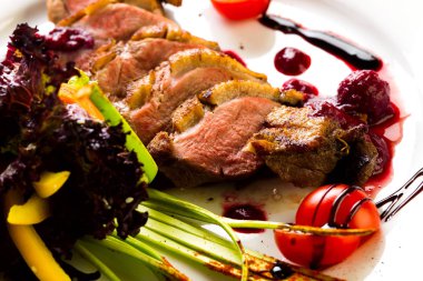 Fırında ördek sebze ve otlar stüdyo ışık beyaz bir tabakta yemek