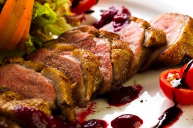 Fırında ördek sebze ve otlar stüdyo ışık beyaz bir tabakta yemek